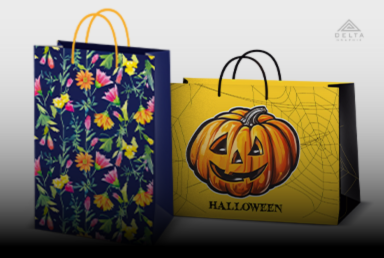 Zdjęcie przestawia produkty z kategorii Torebki Papierowe na stronie Portal DeltaGraphix. Torebka granatowa z motywem kwiatowym oraz żółta z wydrążoną dynią, pajęczynami i napisem halloween.