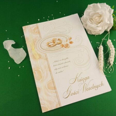 księga gości weselnych, na środku obrączki. w tle ozdobne kwiaty