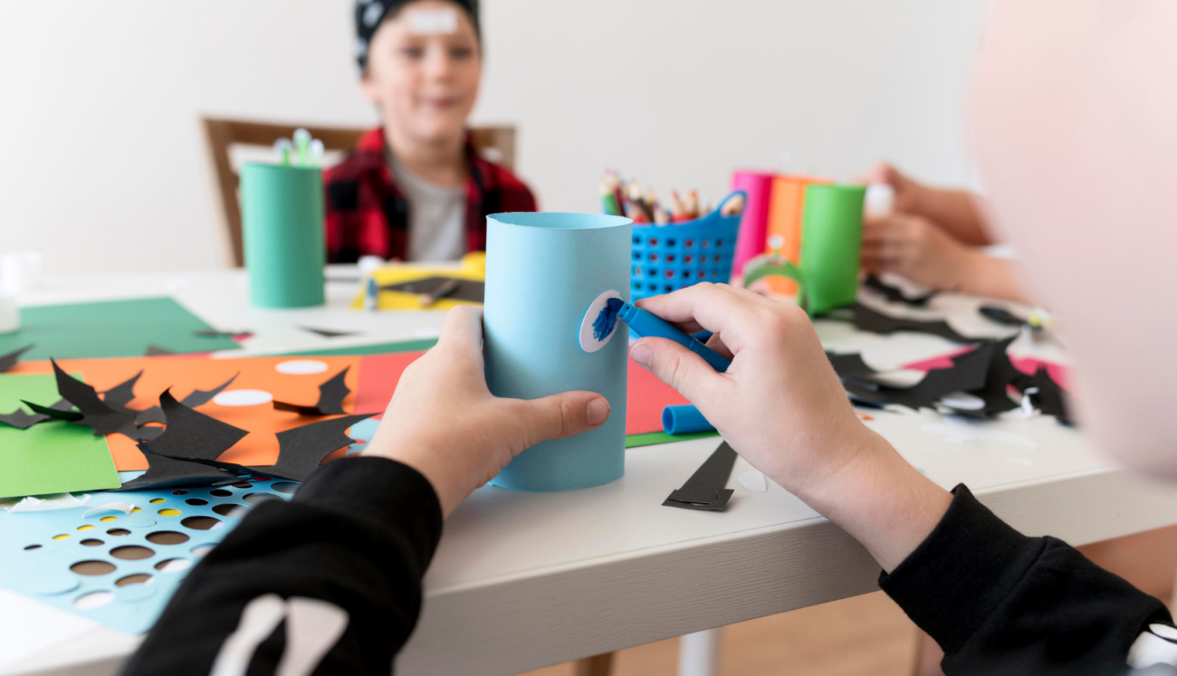 Zdjęcie przedstawia dzieci bawiące się papierem kolorowym.